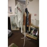 A WHITE METAL COAT RACK WITH TWO LEATHER COATS