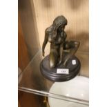 A BRONZE TYPE FIGURE OF A NUDE LADY WITH BADGE