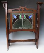 AN EARLY 20TH CENTURY OAK GLAZED ART NOUVEAU FIRE SCREEN, the glass panel with coloured and leaded