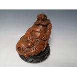 A CHINESE BAMBOO CARVED IMMORTAL, raised on a circular hardwood stand, Figure H 13 cm, W 15 cm