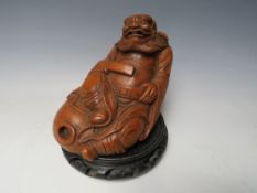 A CHINESE BAMBOO CARVED IMMORTAL, raised on a circular hardwood stand, Figure H 13 cm, W 15 cm
