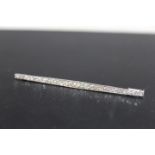 A GRADUATING DIAMOND SET BROOCH, with twenty nine brilliant cut diamonds channel set in unmarked