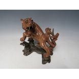 A 20TH CENTURY JAPANESE CARVED HARDWOOD TIGER, on a naturalistic wood base, H 19.5 cm, W 18 cm