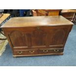AN OAK MULE CHEST, the hinged lid above a fielded triple panel front with two drawers below,