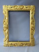 A LATE 18TH / EARLY 19TH CENTURY CARVED WOODEN DECORATIVE GOLD FRAME, frame W 12 cm, rebate 65 x