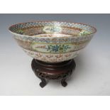 A CHINESE PORCELAIN BOWL DECORATED WITH TWO DRAGONS, raised on a hardwood pierced stand, Bowl H 7.