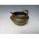 AN ORIENTAL TWIN HANDLED BRONZE LOTUS SHAPED CENSOR, with six character mark to base, H 11.5 cm,