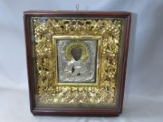 A LATE 18TH / EARLY 19TH CENTURY BOXED AND GLAZED DECORATIVE GOLD FRAME, containing a faded Icon