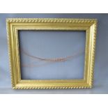 A 19TH CENTURY GOLD FRAME WITH FLOWER DESIGN TO INNER EDGE, leaf design to outer edge, frame W 11
