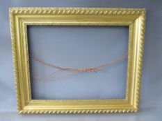 A 19TH CENTURY GOLD FRAME WITH FLOWER DESIGN TO INNER EDGE, leaf design to outer edge, frame W 11