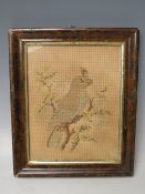 A LATE 18TH / EARLY 19TH CENTURY NEEDLEWORK, depicting a bird resting on a branch, framed and