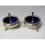 A PAIR OF HALLMARKED SILVER SALTS WITH BLUE GLASS LINERS - LONDON 1903, makers mark for SWS & Co.,