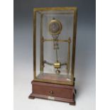 AN EARLY ELECTRIC FOUR GLASS TIMEPIECE, the brass frame supporting a small clock movement and soft