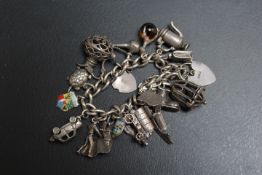 A SILVER CHARM BRACELET ADORNED WITH APPROX 20 CHARMS, approx weight 73.1g