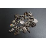 A SILVER CHARM BRACELET ADORNED WITH APPROX 20 CHARMS, approx weight 73.1g