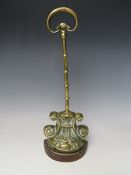 A LATE 19TH CENTURY BRASS DOOR STOP, on a cast demi-lune base, H 37.5 cm