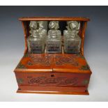 A EARLY 20TH CENTURY OAK CARVED THREE DECANTER TANTALUS, the tantalus with twin opening