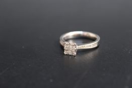 A HALLMARKED 18 CARAT WHITE GOLD DIAMOND RING, in a modern setting with four princess cut tension