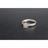 A HALLMARKED 18 CARAT WHITE GOLD DIAMOND RING, in a modern setting with four princess cut tension