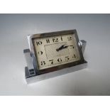 A FORTNUM & MASON ART DECO CHROMED TABLE CLOCK, the rectangular clock face swivelling on two