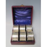 A CASED SET OF SIX EDWARDIAN HALLMARKED SILVER NAPKIN RINGS - BIRMINGHAM 1908, makers mark for J