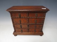 A VICTORIAN MINIATURE OAK COLLECTORS CHEST OF EIGHT DRAWERS, with beadwork detail, raised on bun