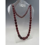 A VINTAGE CHERRY AMBER GRADUATED BEAD NECKLACE, single strand, no fastener, central bead W 2.5 cm,