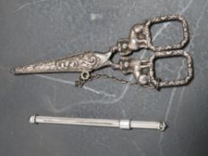 A PAIR OF ANTIQUE SEWING SCISSORS WITH COVER TOGETHER WITH A WHITE METAL COCKTAIL STIRRER (2)
