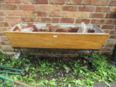 A VINTAGE WOODEN TROUGH ON WROUGHT IRON BASE