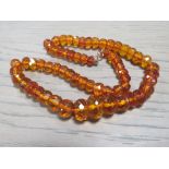 AN ART DECO FACETED AMBER BEAD NECKLACE