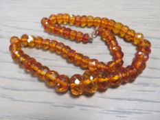 AN ART DECO FACETED AMBER BEAD NECKLACE