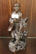 A CARVED ORIENTAL HARDWOOD FIGURE OF A YOUNG MAN WITH DOG