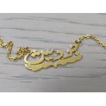 A YELLOW METAL NECKLACE WITH ARABIC SCRIPT CENTRAL PANEL, APPROX 12.5 G