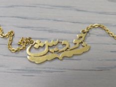 A YELLOW METAL NECKLACE WITH ARABIC SCRIPT CENTRAL PANEL, APPROX 12.5 G