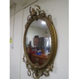 A 19TH CENTURY LARGE GILT OVAL WALL MIRROR WITH TWIN CANDLE SCONCE, having a scrolling foliate