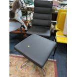 A MODERN BLACK SWIVEL ARMCHAIR WITH MATCHING FOOTSTOOL (2)