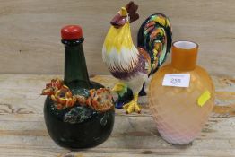A NOVELTY MUSICAL BOTTLE TOGETHER WITH A SATIN GLASS VASE AND A FIGURE OF A COCKEREL (3)