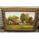 LARGE GILT FRAMED OIL ON CANVAS BUILDINGS IN A RURAL LANDSCAPE, SIGNED LOWER RIGHT
