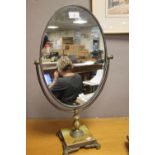AN OVAL DRESSING TABLE MIRROR
