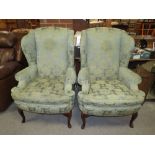 A PAIR OF GREEN UPHOLSTERED WING-BACK ARMCHAIRS