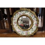 A GILT MOUNTED MIRROR WITH CERAMIC BORDER