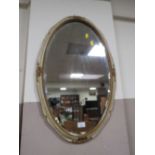 AN OVAL WALL MIRROR