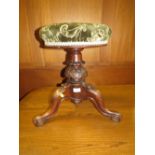 A VICTORIAN CARVED REVOLVING PIANO STOOL