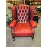 AN OXBLOOD RED LEATHER CLASSICAL WINGBACK ARMCHAIR