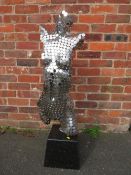 A MODERN SCULPTURE OF A FEMALE TORSO MADE FROM STAINLESS STEEL DISCS MOUNTED ON A MARBLED BASE H 109