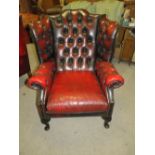 AN OX-BLOOD RED CLASSICAL WINGBACK ARMCHAIR