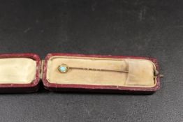 AN ANTIQUE GOLD STICK PIN SET WITH AN OPAL MARKED 15ct