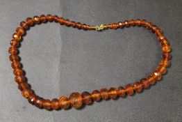 AN AMBER FACETED BEAD NECKLACE