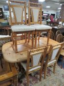 A HONEY PINE DINING TABLE AND SIX CHAIRS - ONE SPARE LEAF A/F