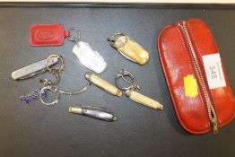 A SMALL VINTAGE LEATHER PURSE CONTAINING VARIOUS POCKET FRUIT KNIFES